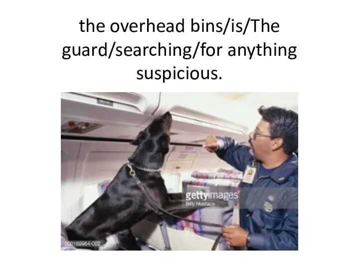 the overhead bins/is/The guard/searching/for anything suspicious.