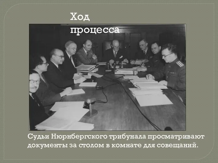 Судьи Нюрнбергского трибунала просматривают документы за столом в комнате для совещаний. Ход процесса