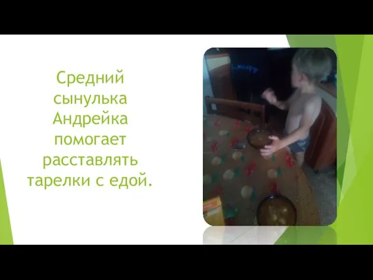 Средний сынулька Андрейка помогает расставлять тарелки с едой.