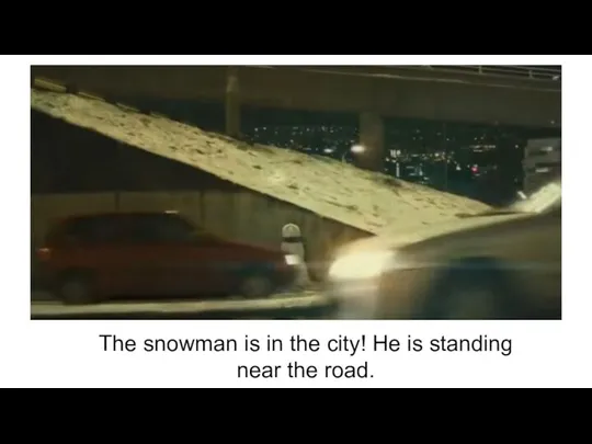 The snowman is in the city! He is standing near the road.