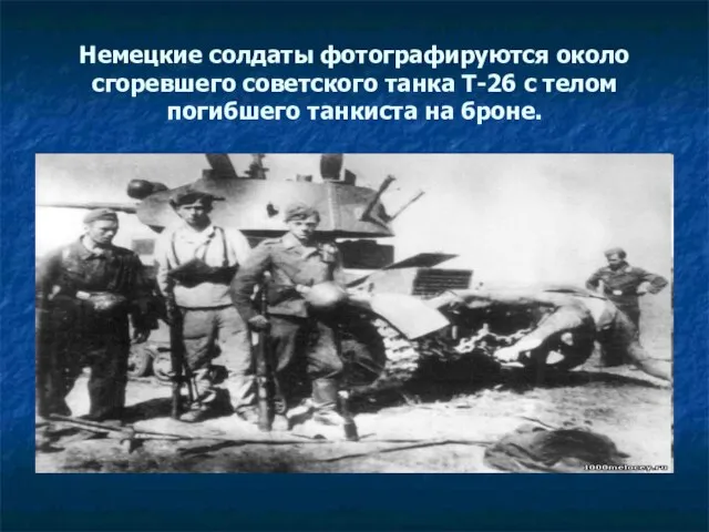 Немецкие солдаты фотографируются около сгоревшего советского танка Т-26 с телом погибшего танкиста на броне.