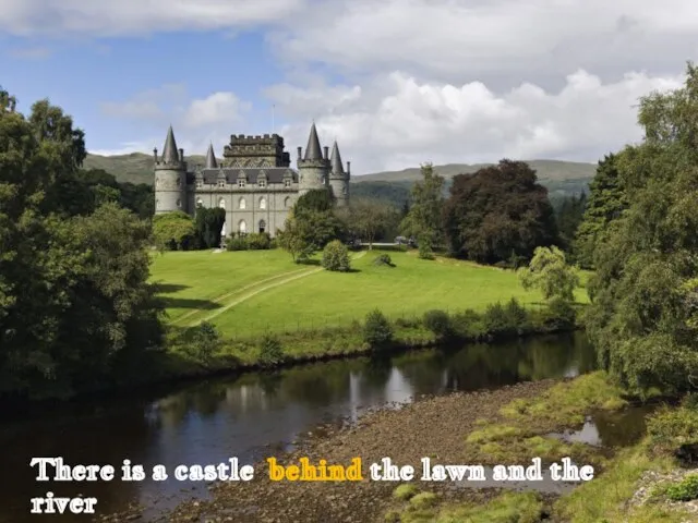 There is a castle behind the lawn and the river