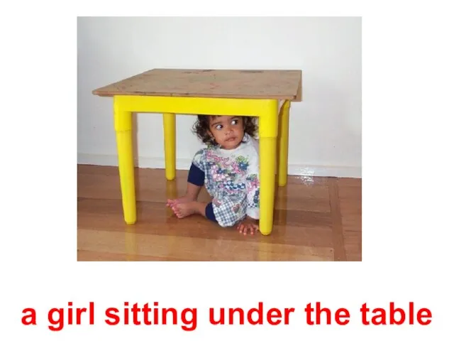 a girl sitting under the table