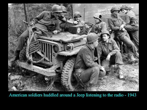 American soldiers huddled around a Jeep listening to the radio - 1943