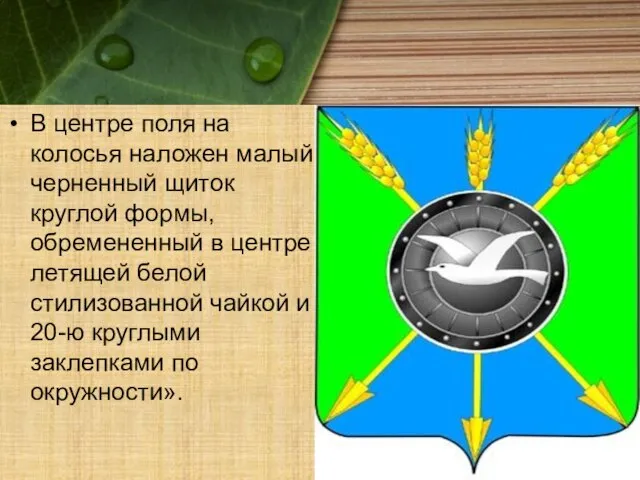 В центре поля на колосья наложен малый черненный щиток круглой формы, обремененный