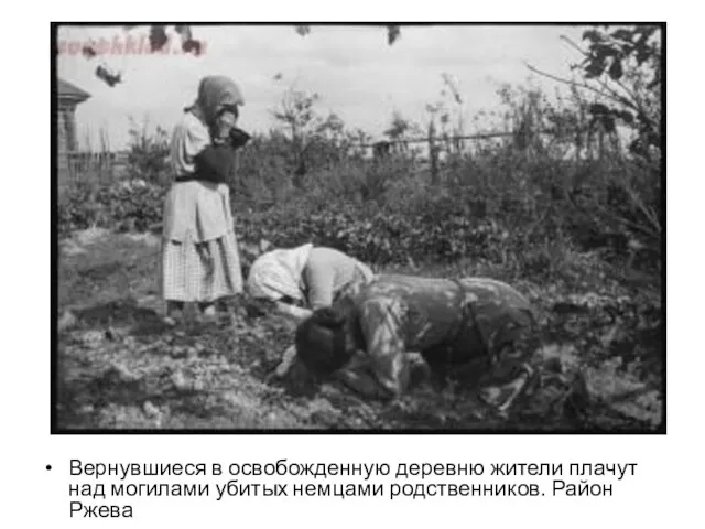 Вернувшиеся в освобожденную деревню жители плачут над могилами убитых немцами родственников. Район Ржева
