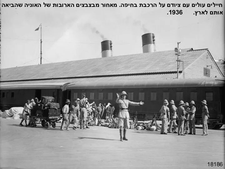 18186 חיילים עולים עם ציודם על הרכבת בחיפה. מאחור מבצבצים הארובות של