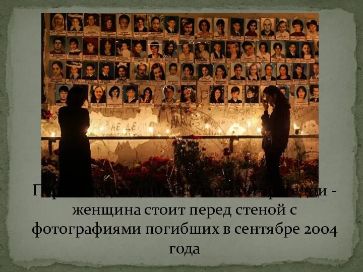 Первая годовщина бесланской трагедии - женщина стоит перед стеной с фотографиями погибших в сентябре 2004 года